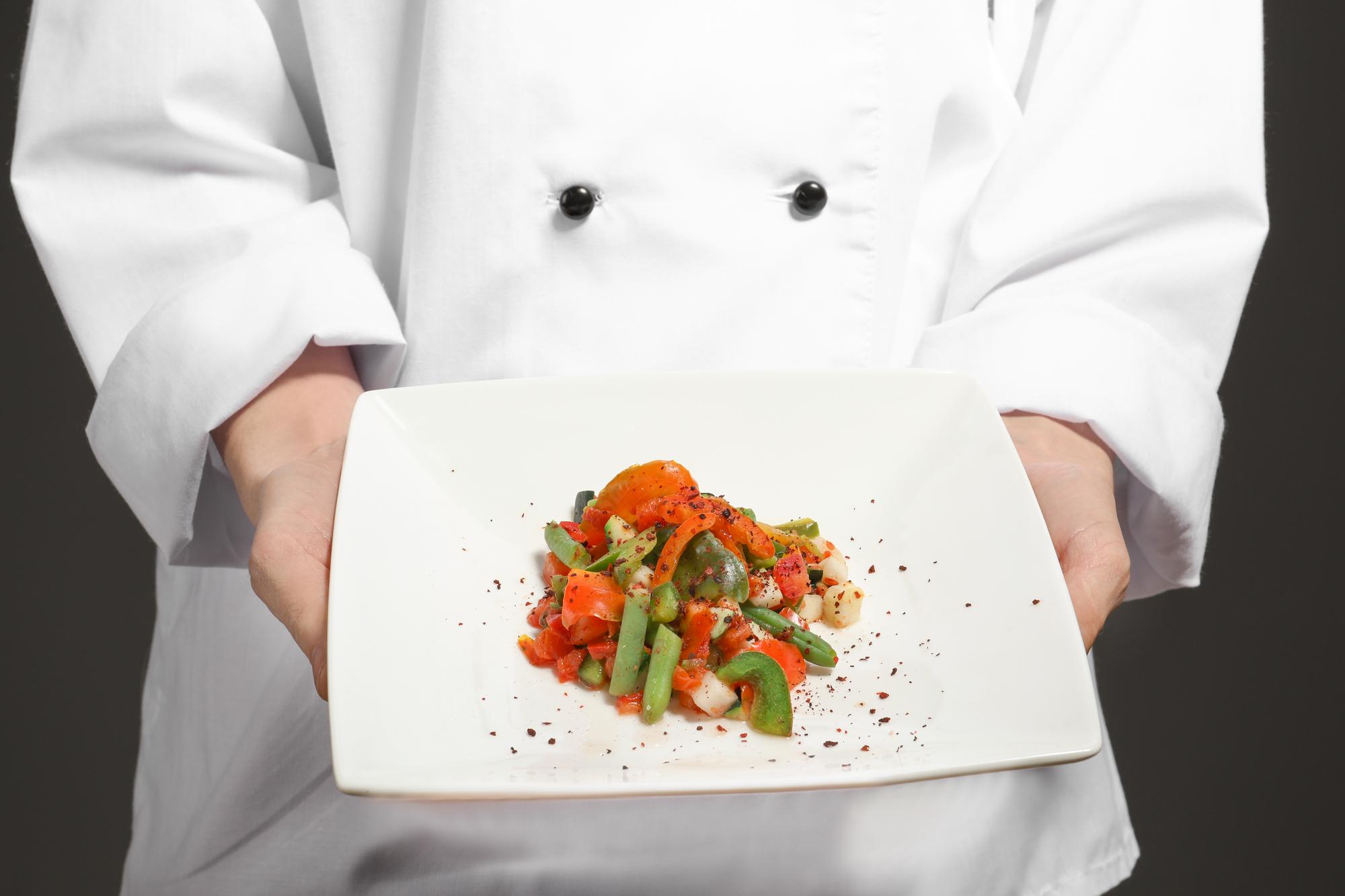 Instructor plating a dish in a bright kitchen